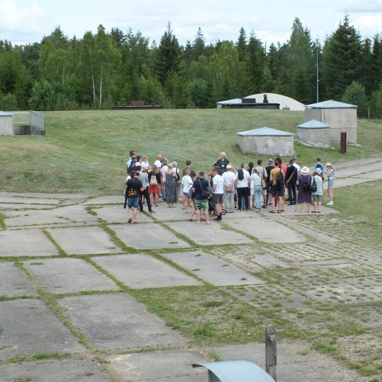 Žmonės klausosi, ką pasakoja gidas