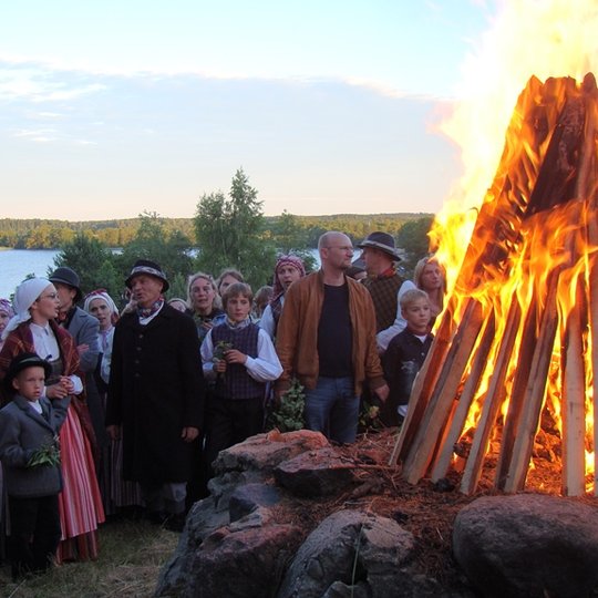 Joninių dalyviai dainuoja prie laužo